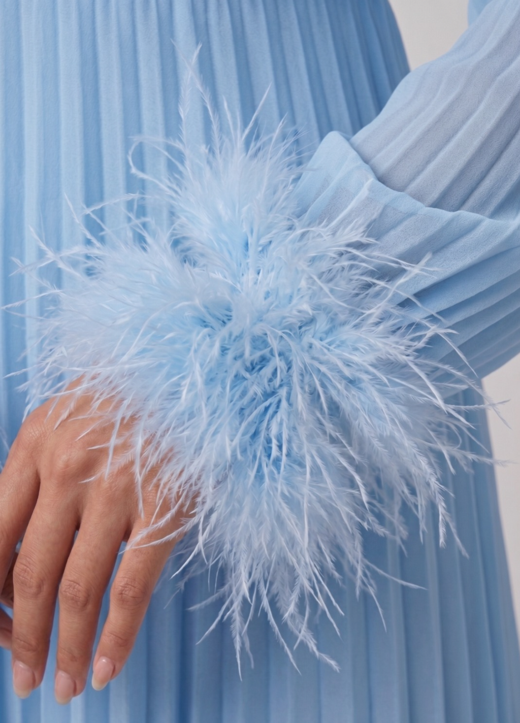 Light blue dress with feathered sleeves against a light background