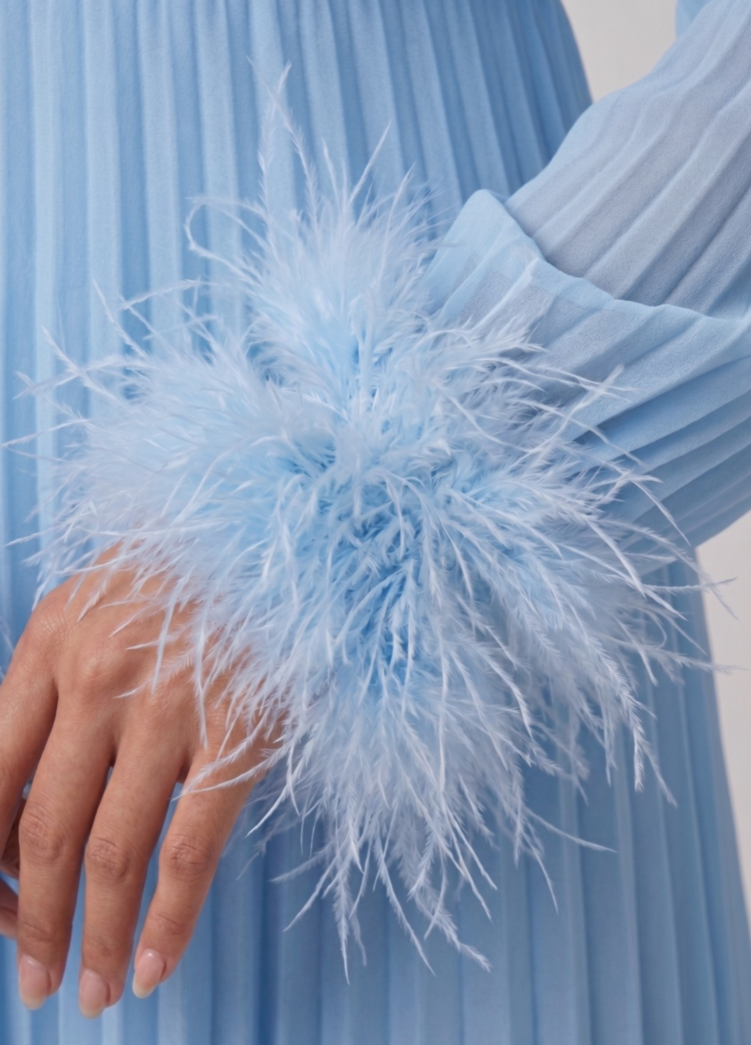 Light blue dress with feathered sleeves against a light background