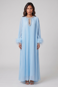 Woman wearing a light blue dress with lace details on a white background