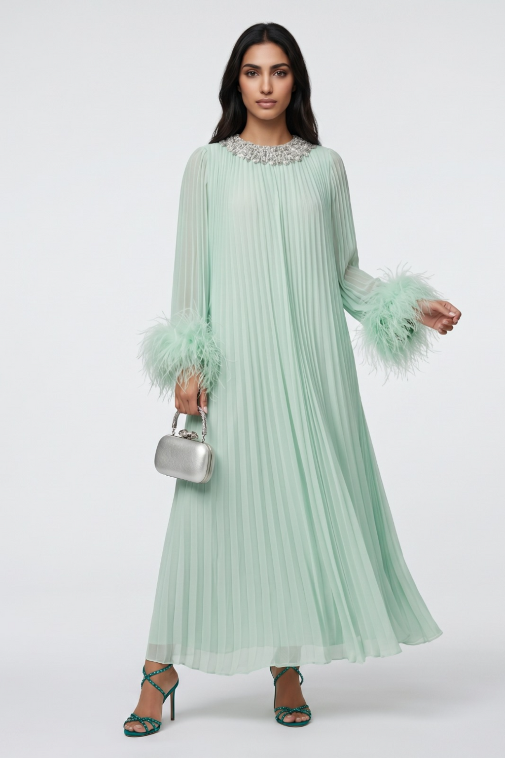 Woman wearing a light green dress with feathered sleeves on a white background