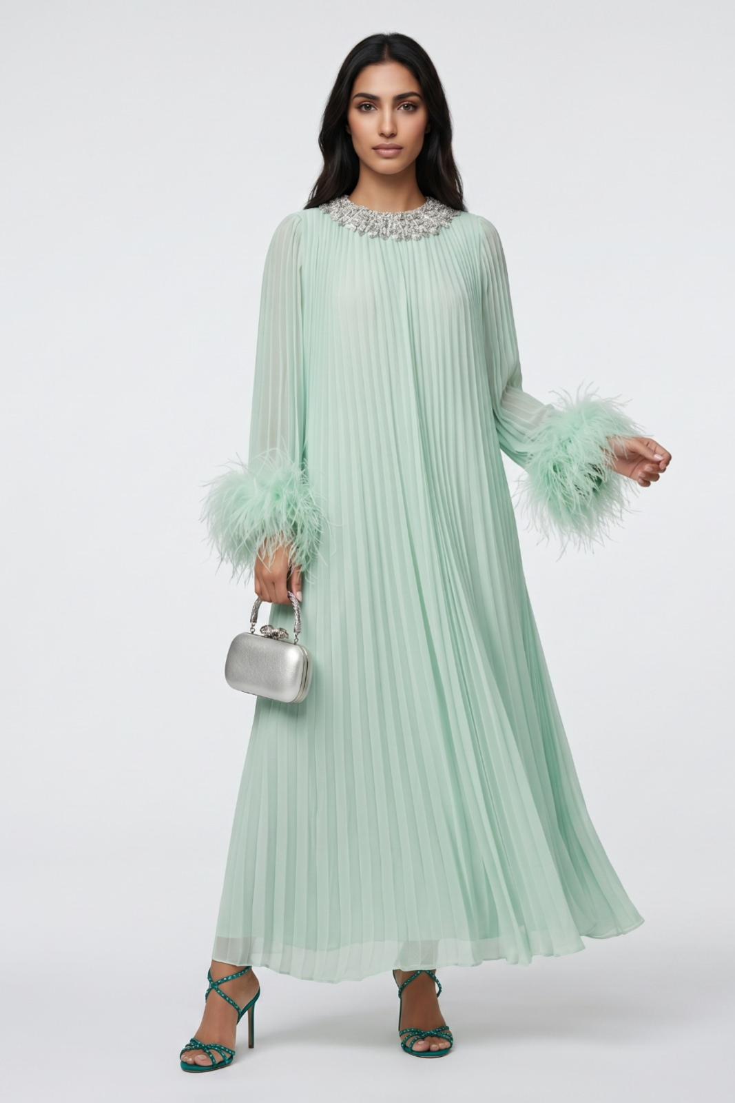 Woman wearing a light green dress with feathered sleeves on a white background