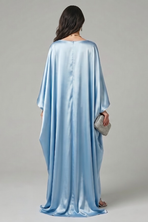 Woman wearing a light blue satin abaya butterfly dress against a gray background