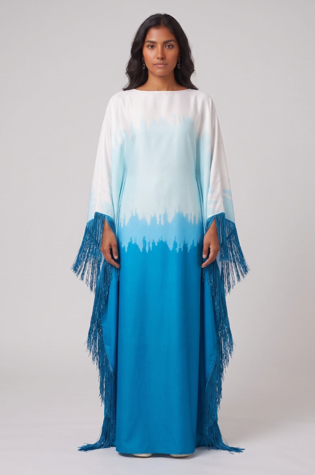 Woman wearing a long, colorful dress abaya with a gradient from white to blue on a plain background