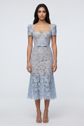 Woman wearing a light blue lace dress on a white background