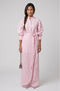 Woman wearing a linen pink three piece set with a belt on a white background